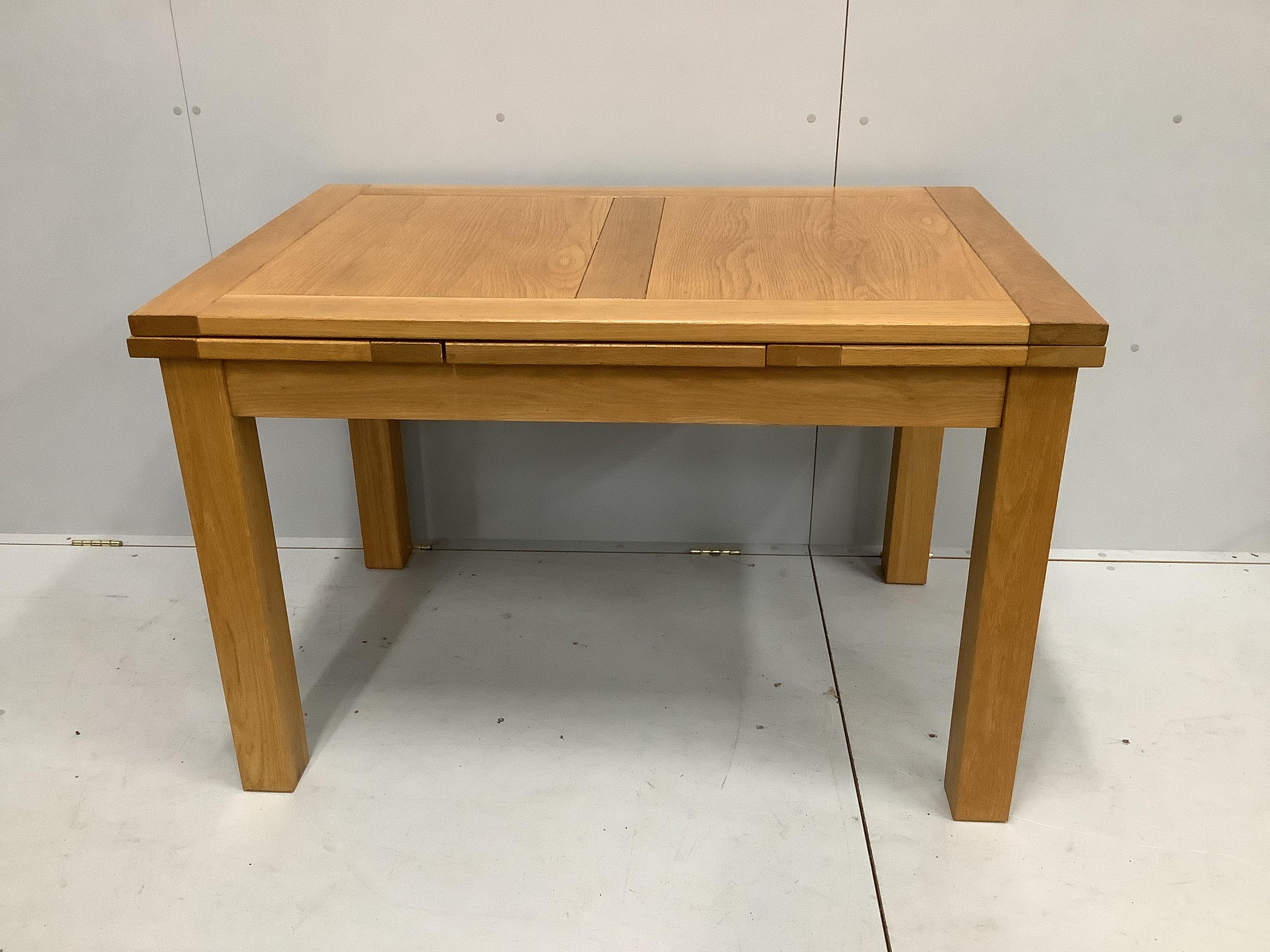 A contemporary oak draw leaf extending dining table, width 200cm extended, depth 80cm, height 78cm together with a set of four matching dining chairs